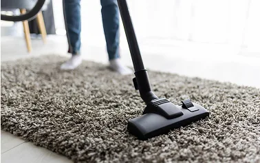 Vacuum cleaning a shaggy carpet in a modern home, showing deep cleaning of high-pile carpet with professional equipment
